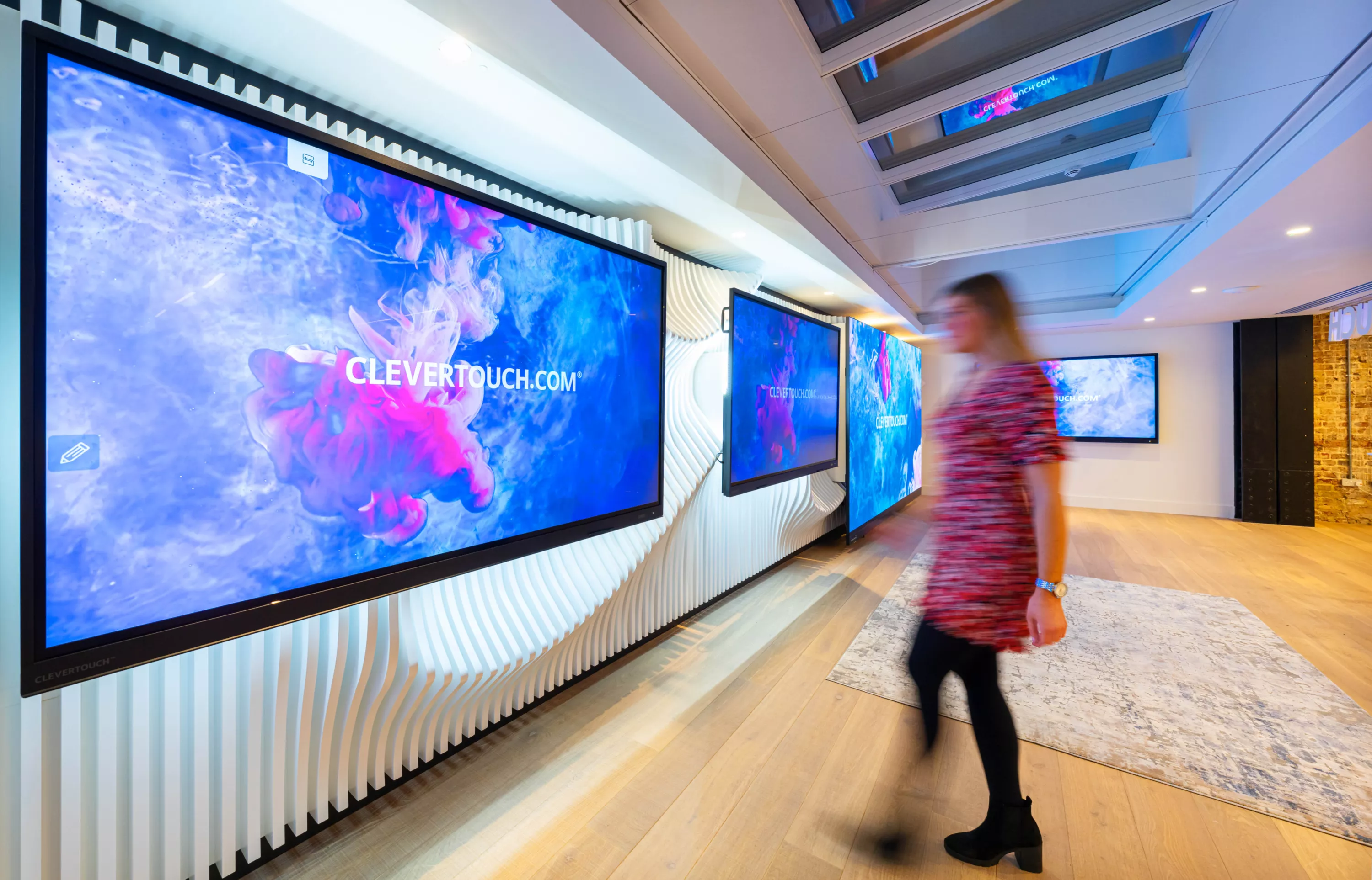 A person walking towards the screens at the Clevertouch Showroom