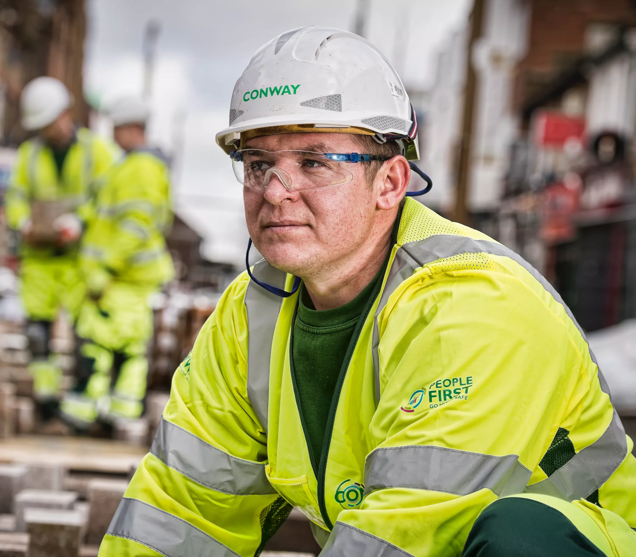 A person in FM Conway branded high viz, safety glasses and hard hat