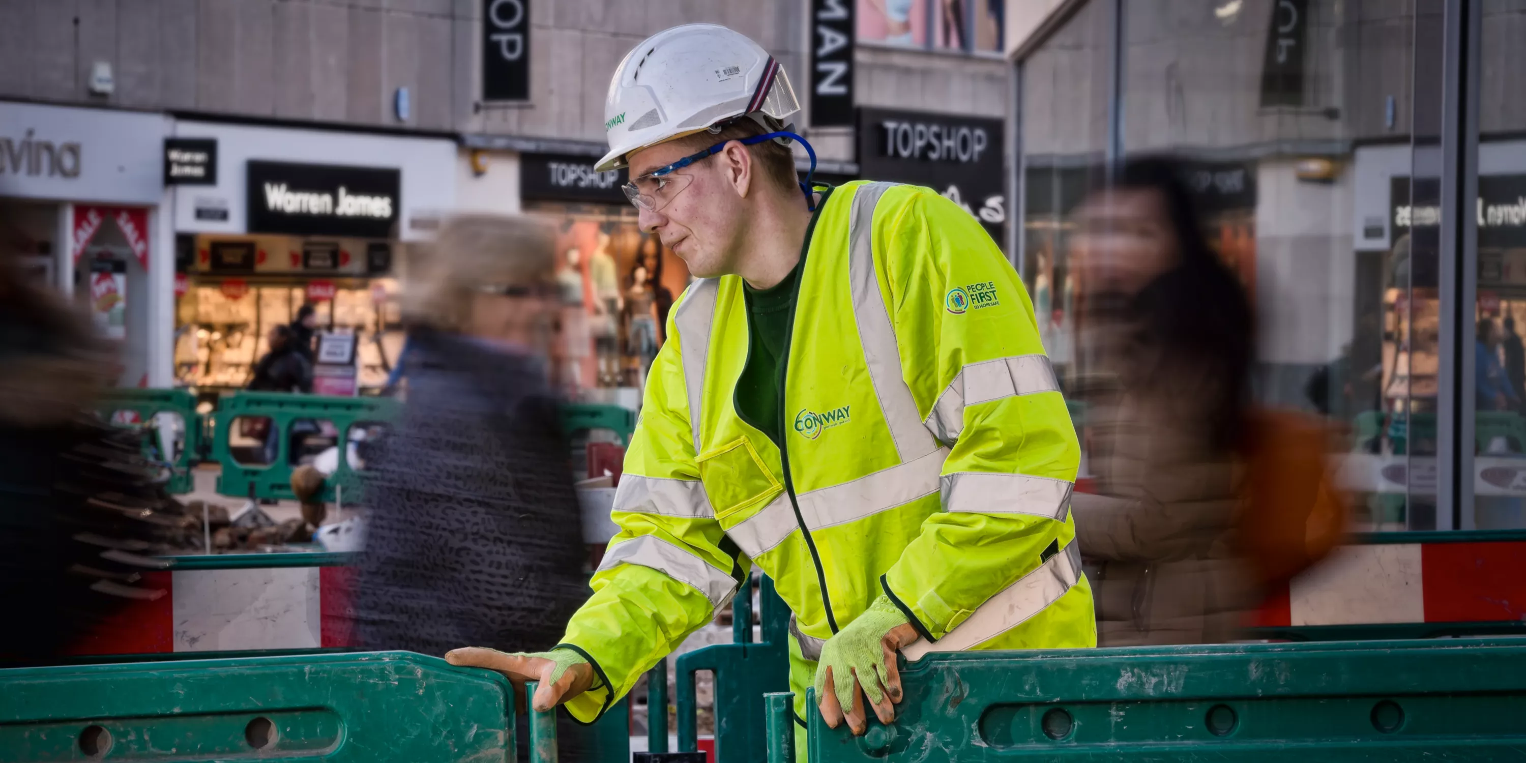 An FM Conway employee putting up a barrier on a high street