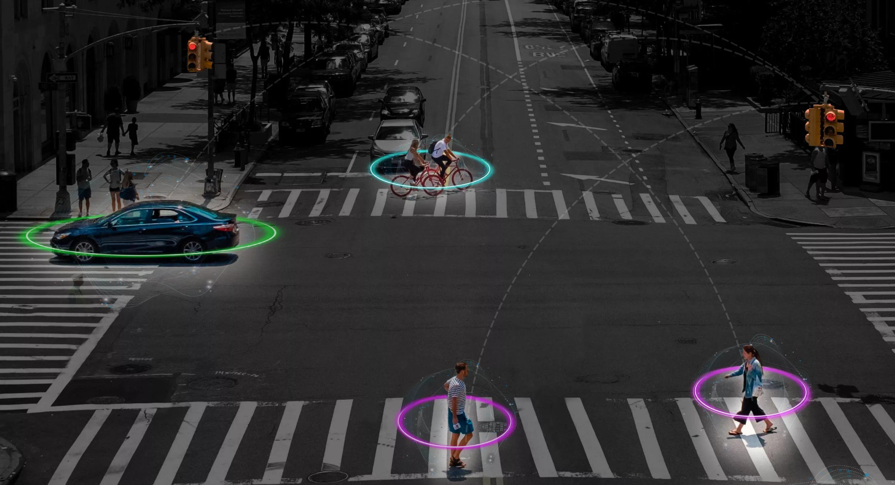 A city intersection with pedestrians, cyclists and a car, each highlighted by glowing digital rings, symbolising smart detection technology